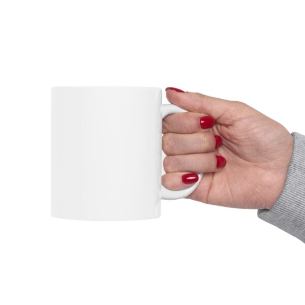 A hand holding a BOL mug.